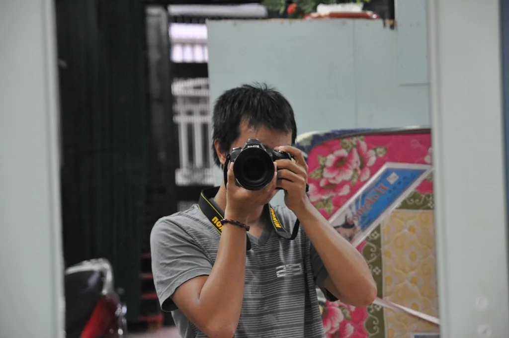 Self-portrait in a mirror holding the first camera, a Nikon D90