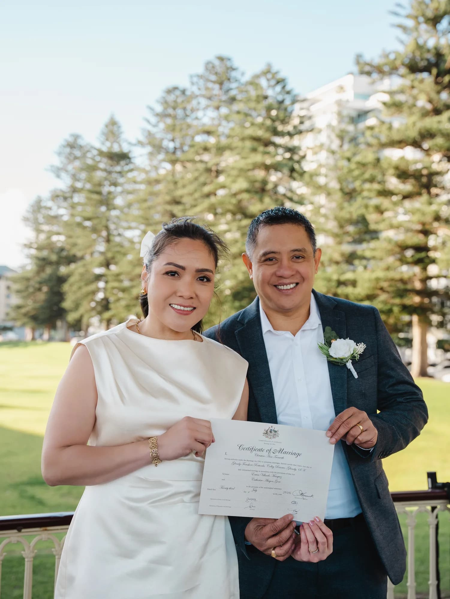 A couple holding their Certificate of Marriage after an outdoor ceremony in Adelaide