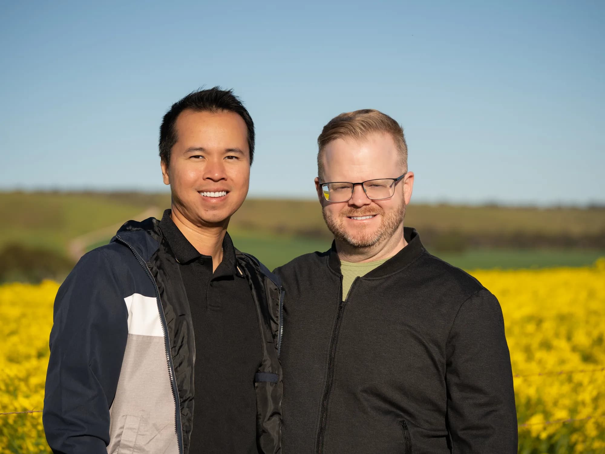 Ricky and Mark Lee standing together in a canola field
