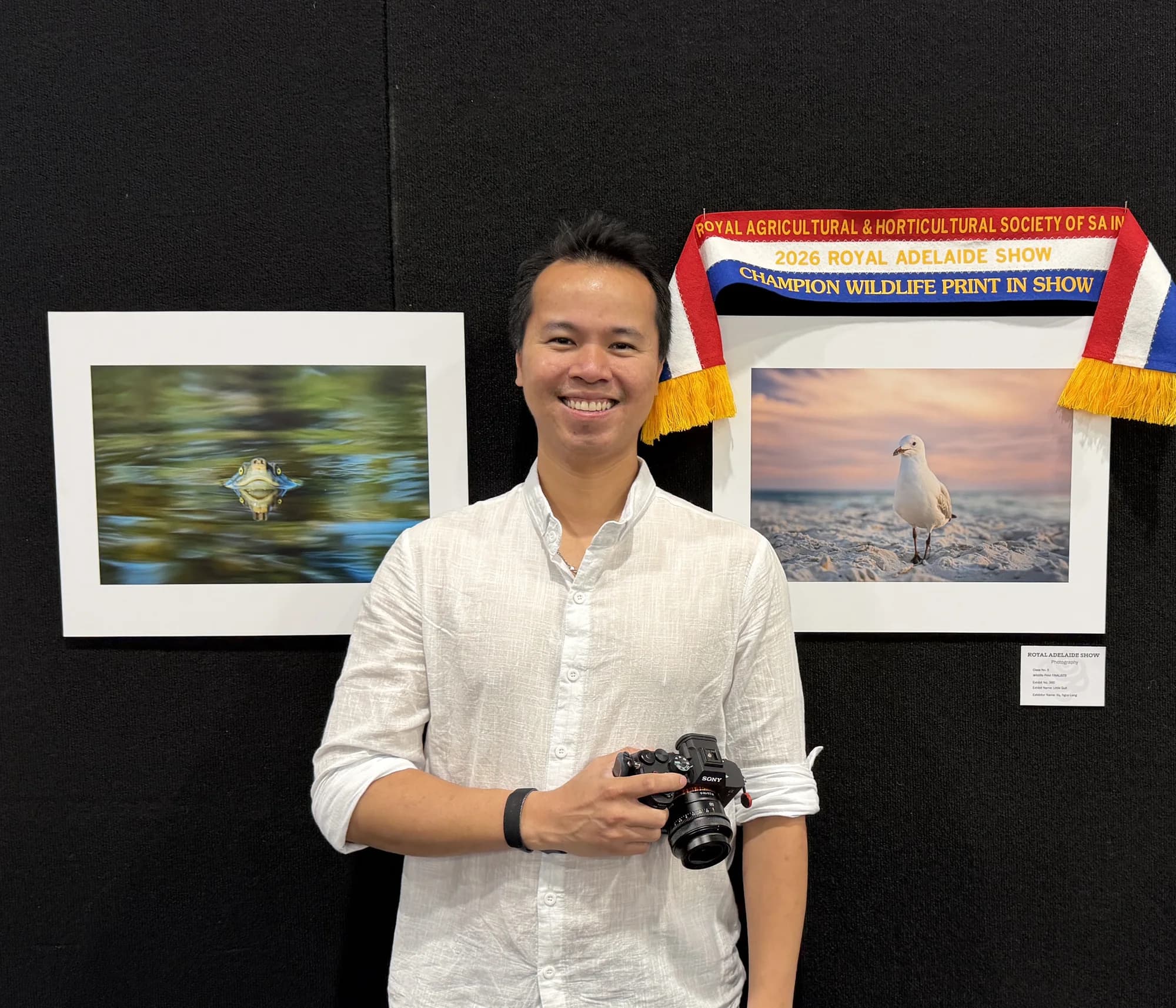 Ricky standing beside his winning print and ribbon at the Royal Adelaide Show exhibition