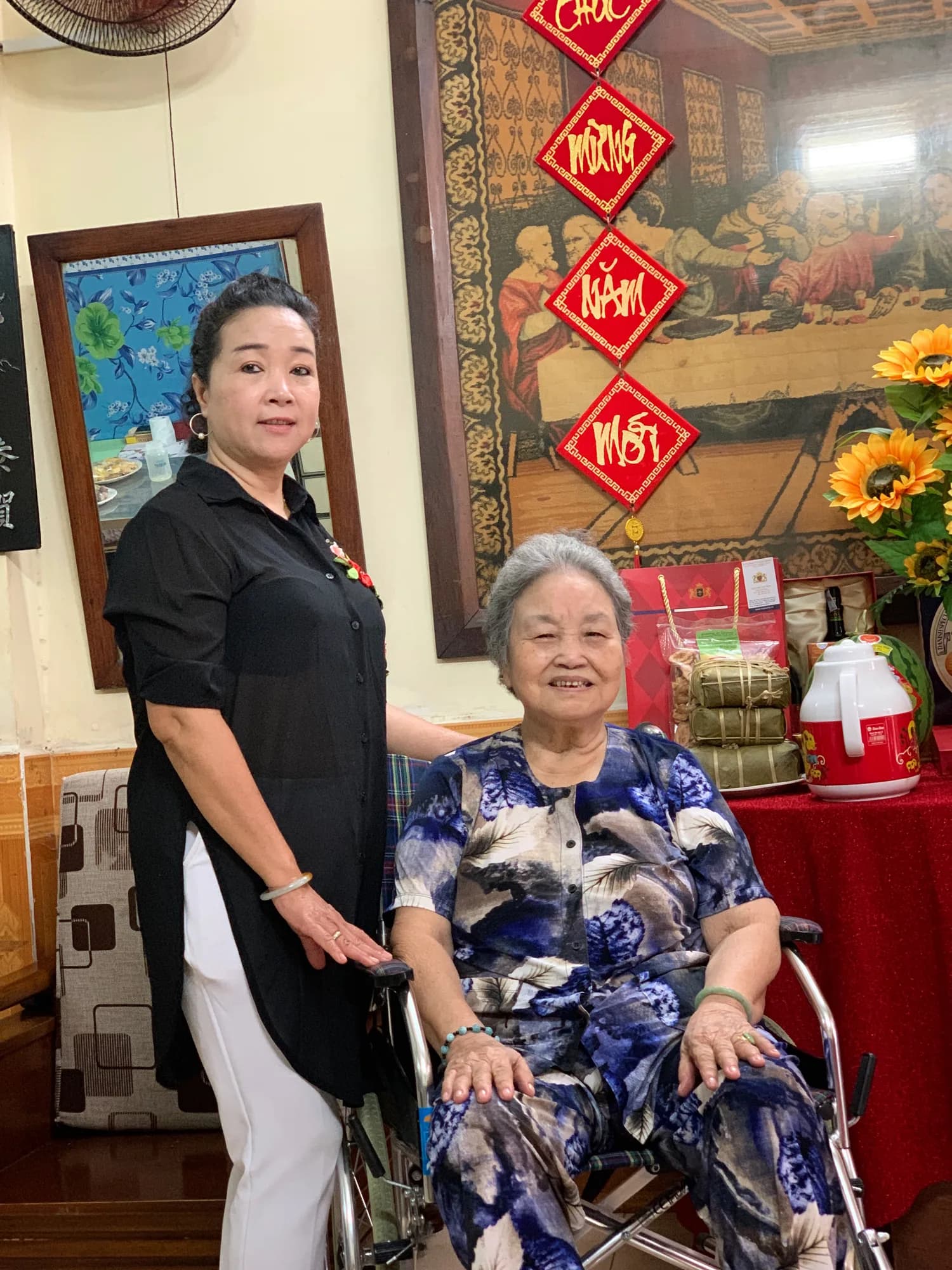 Ricky's grandmother, seated, with his mother standing beside her during a Tet holiday gathering