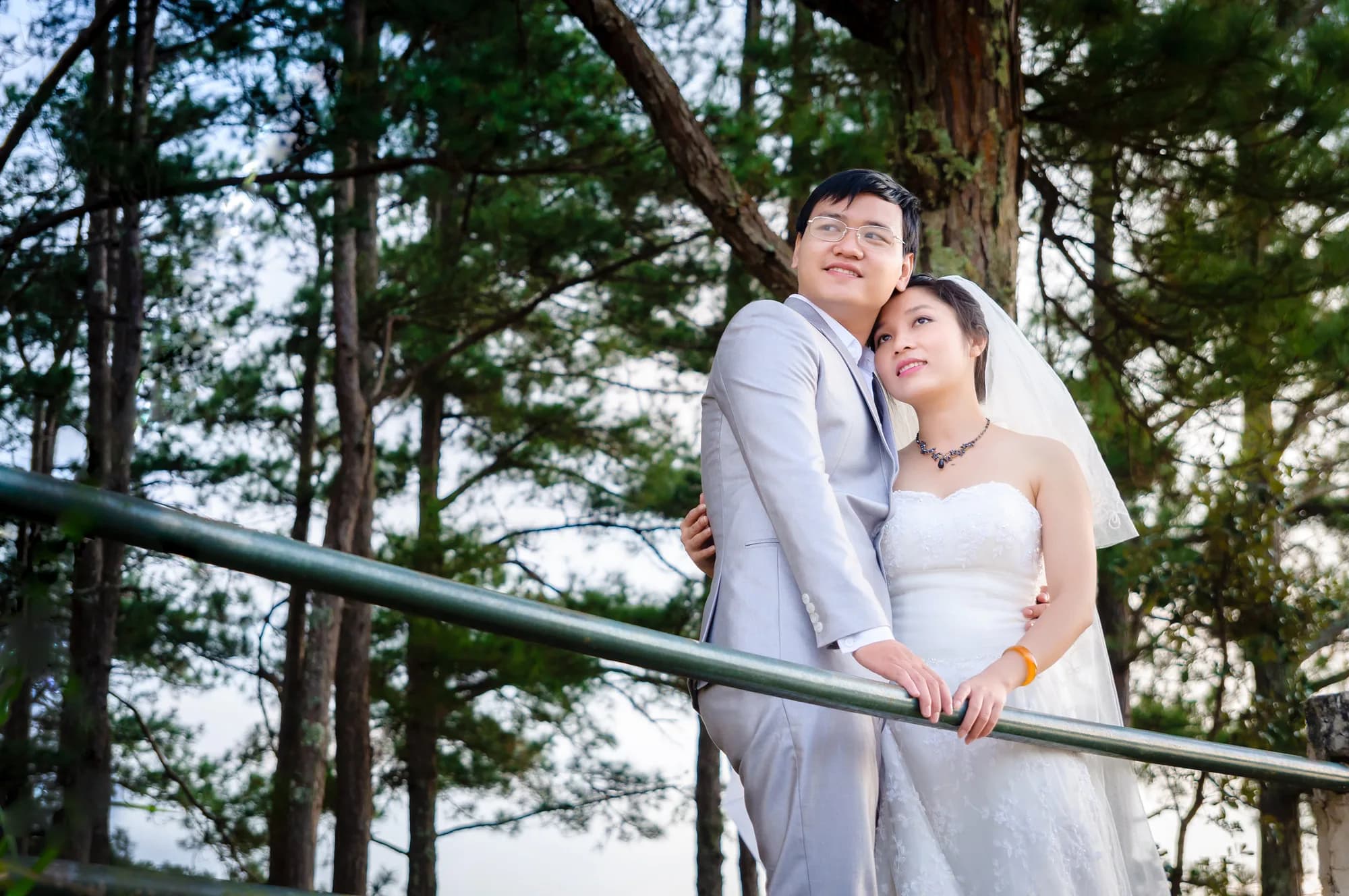 A newly married couple embracing quietly in a pine forest